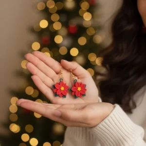 Boucles d'oreilles Étoile de Noël présentées en main pour apprécier la taille et l'éclat.