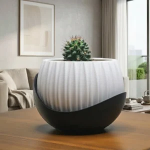 Cache-pot Eclipse en impression 3D accueillant une plante verte sur une étagère.