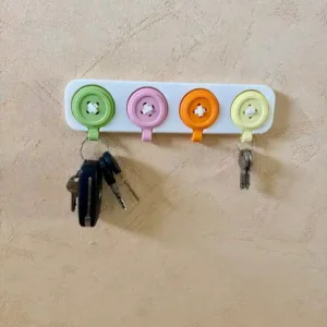 Porte-clés mural original Nodum avec un rail blanc fixé au mur et quatre boutons colorés vert rose orange jaune servant de accroche clés