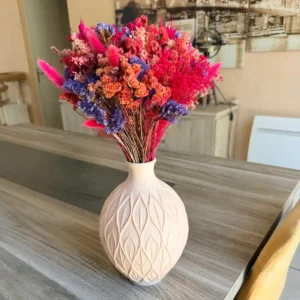 Vase grand format couleur crème avec motifs sculptés de feuilles entrelacées en relief, posé en décoration d'intérieur.