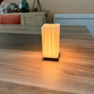 Lampe d'ambiance design Fold imprimée en 3D avec un corps blanc plissé et une base couleur bois lumière jaune