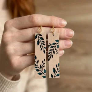 Paire de boucles d'oreilles feuillage style nature tenues en main