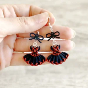 Détail des boucles d'oreilles articulées Flamenco noir et rouge tenues en main