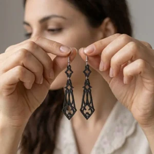 Paire de boucles d'oreilles pendantes noires ajourées style gothique chic tenues en main