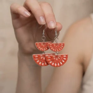 Paire de boucles d'oreilles rouges pendantes a deux étages tenue en main