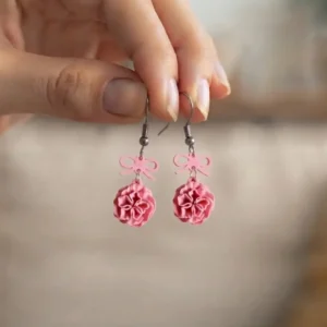 Vue rapprochée des boucles d'oreilles pendantes roses en impression 3D.