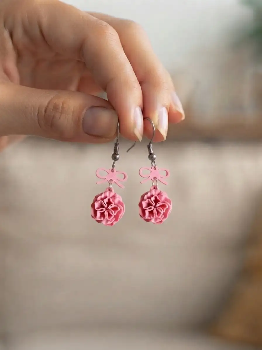 Vue rapprochée des boucles d'oreilles pendantes roses en impression 3D.