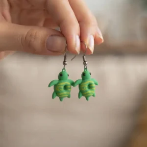 Gros plan sur les boucles d'oreilles tortue donuts bicolores portées à l'oreille, montrant leur légèreté et leur design original.