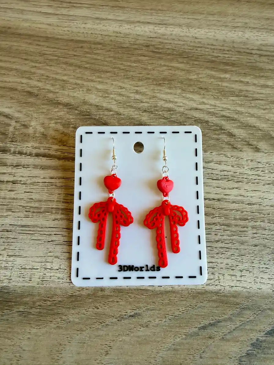 Paire de boucles d'oreilles Ruban d'Amour sur leur support de présentation 3DWorlds